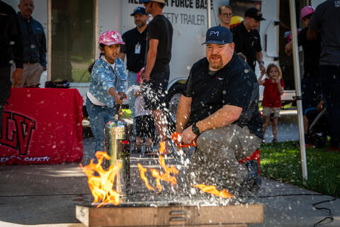 young girl and man using extinguisher on fire
