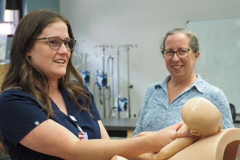 Rachel Matthews, one of the first graduates of UNLV Nursing's Midwifery Program, simulates a birth during a skills lab with Kate Woeber, Ph.D., CNM, MPH, FACNM, the program director