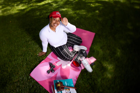 Brie Starks sitting on blanket while wearing UNLV baseball cap