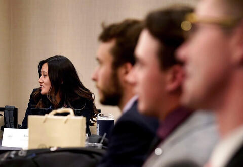 People in a meeting with camera focusing in on a woman.