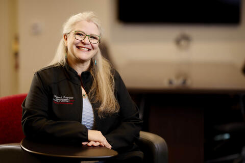 smiling Candyann Humprhies wears pullover representing her department in school of medicine