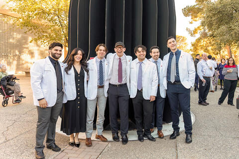 Seven people in white coats