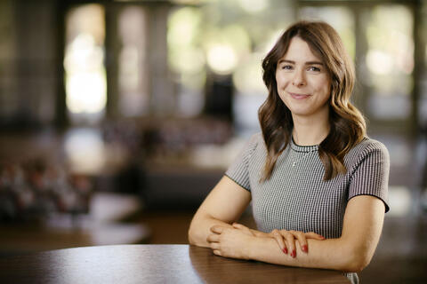 Ariana Turiansky sits at table with folded arms