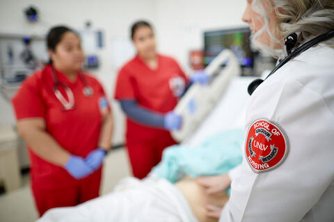 A nurse in training interacts with a patient in a clinical simulation.