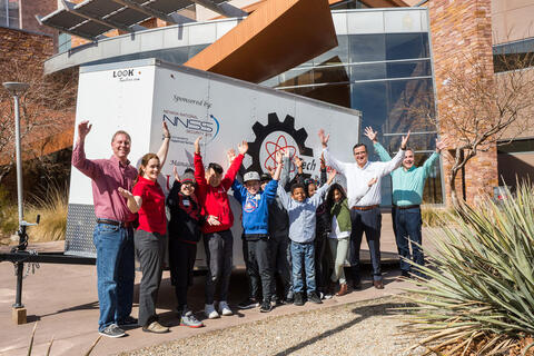 A group of students and instructors standing outside of a building.