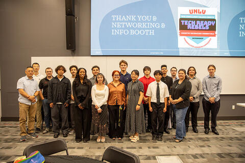 A group of students and mentors posing for a photo at a networking event.