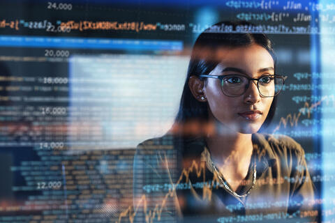 stock image of woman staring at projected code across screen