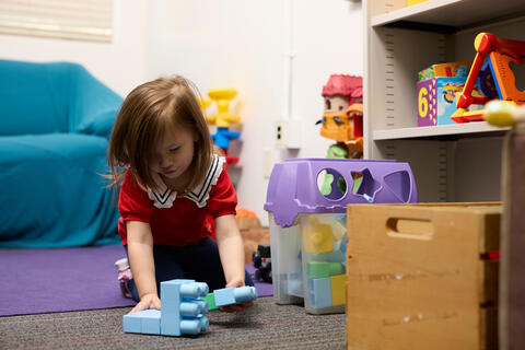young girl plays with toys in living room setting