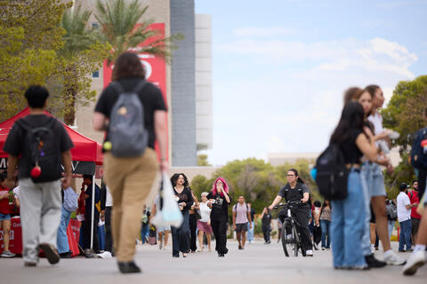 A crowd of students walking and biking on campus