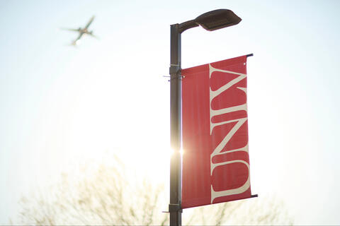 A red banner with the UNLV logo. Above, a plane flies.