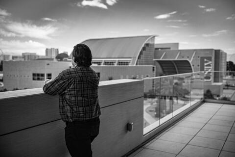 black and white photo of male student and Lied Library in the background