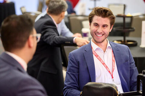 Students in business attire engaged in discussion.