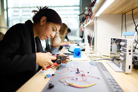 College aged student using wire tools to work on an electrical project