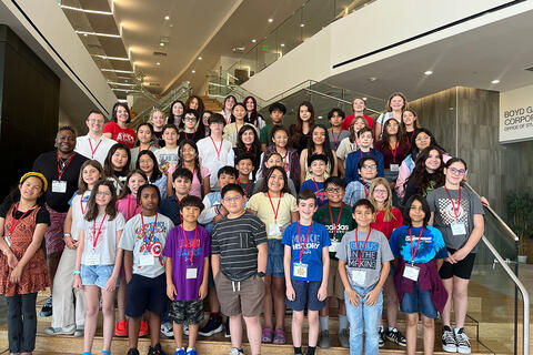 a group of kids posing in front of stairs.