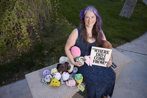 Amanda Morgan surrounded by STD stuffies holding a sign, "Where do I come from?"