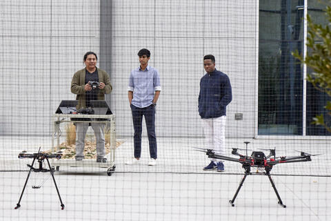3 students flying a drone