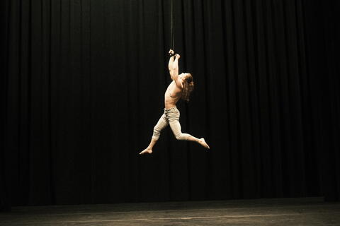 acrobat hanging from ceiling
