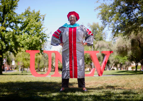 Angelique Burton in front of UNLV sign on academic mall