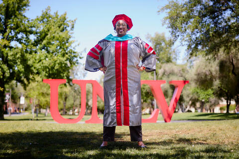 Angelique Burton in front of UNLV sign on academic mall
