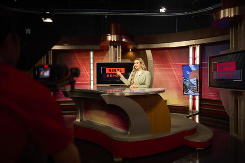 A woman reporter on a TV set