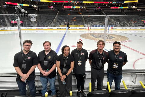 Photo of students standing in front of a hockey stadium