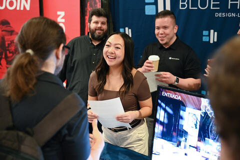 Students and staff interact at an information table
