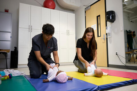 Kayla Ford and an OT student use infant mannequins to practice techniques