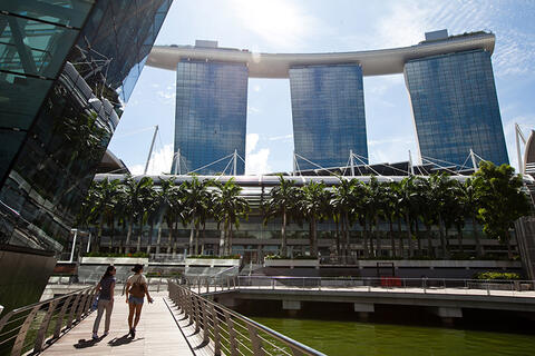 Two women walking alongside large buildings.