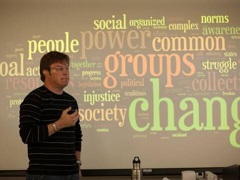 Professor of sociology lecturing in front of class.