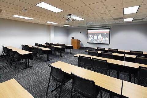Large classroom with desks arranged into rows with an aisle down the middle