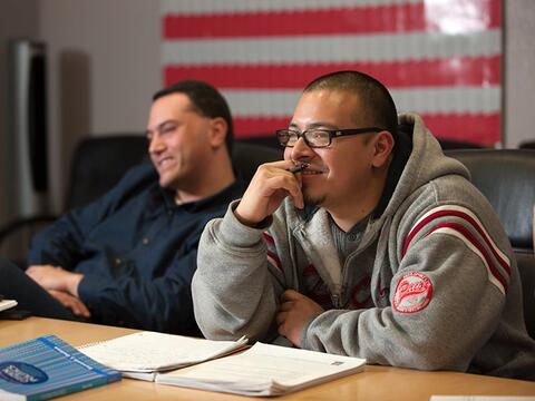 Two students smiling at a table during a class seminar.
