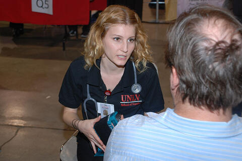 U-N-L-V nurse working with a man