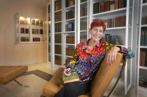 Beverly Rogers seated in home library