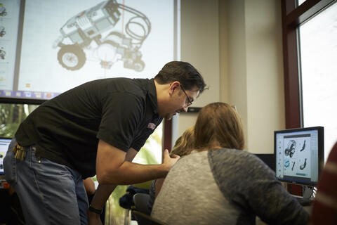 U.N.L.V. instructor at computer talking to two students