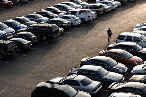 Student walking through a parking lot.