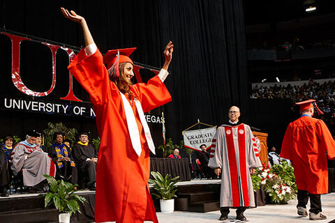 Graduate raises arms at Commencement