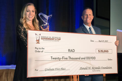 RAD team members hold up giant check