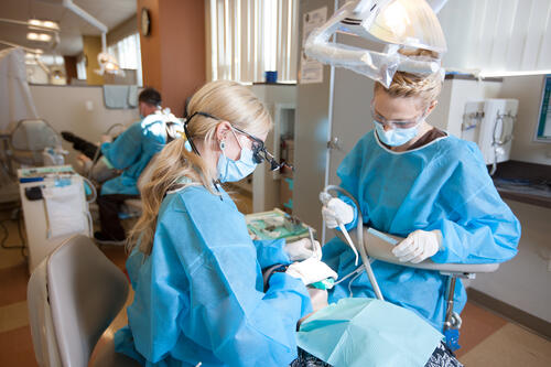 Two students practicing a procedure on a dental manikin