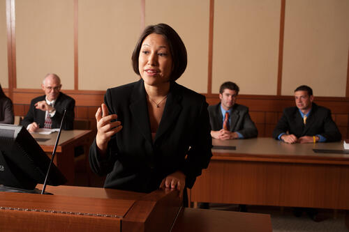 A student participating in a mock trial as peers observe