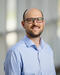 portrait of UNLV professor Richard Oxborough, wearing blue collared button-down shirt and glasses and smiling