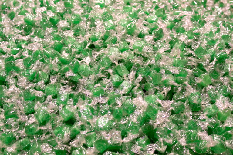 Hundreds of Green hard candies in clear wrappers