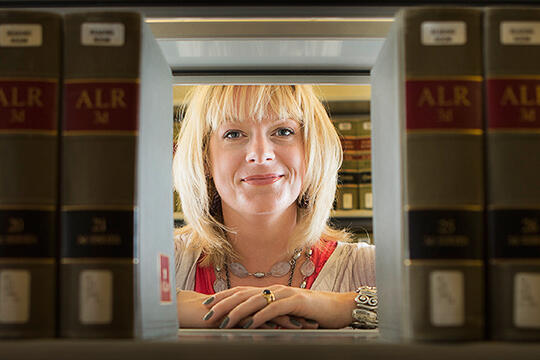 Rebecca Gill looks through a library book shelf