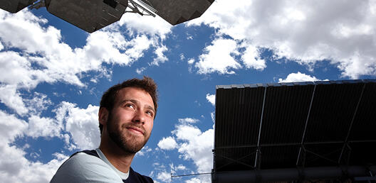 man stands by solar array
