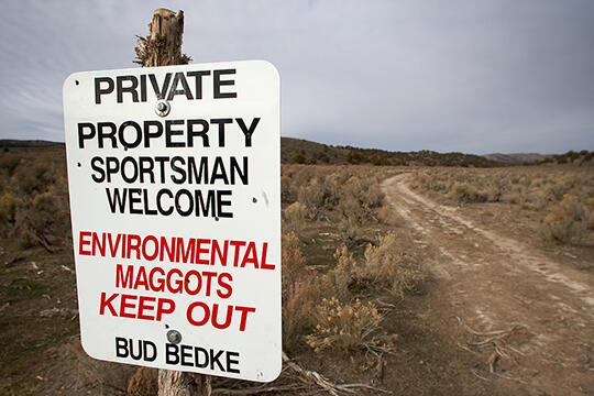 A sign in desert that reads &quot;Private property. Sportsman welcome. Environmental maggots keep out. Bud Bedke&quot;