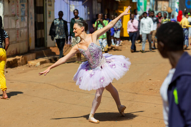 A woman in a ballet tutu dances in an African city