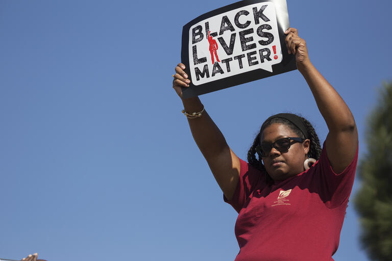 protester holding sign that reads, &quot;Black Lives Matter&quot;