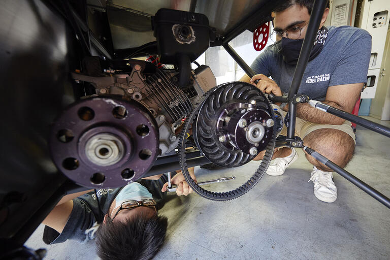 two people working on an engine