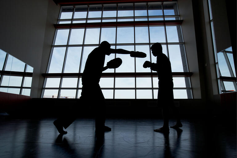 Two boxer in silhouette spar
