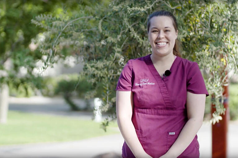 woman outside in medical scrubs