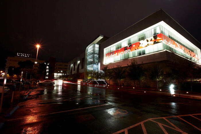 Night shot of the side of the Student Union on a rainy day.